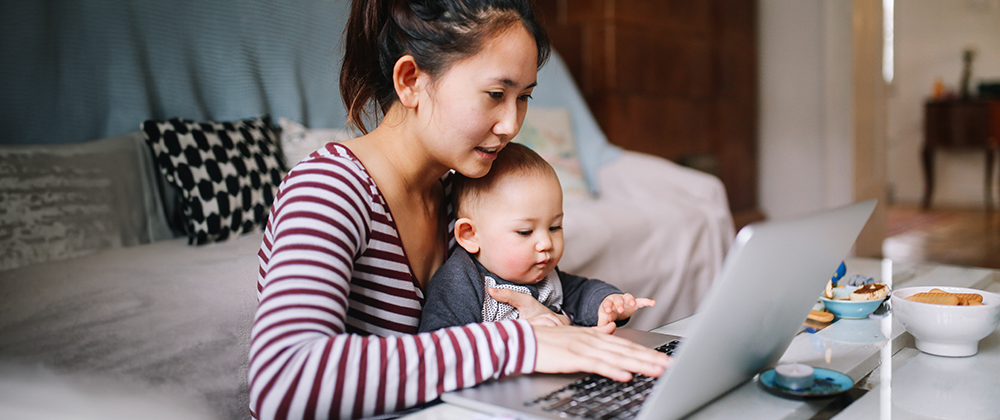 Woman with a baby using a laptop
